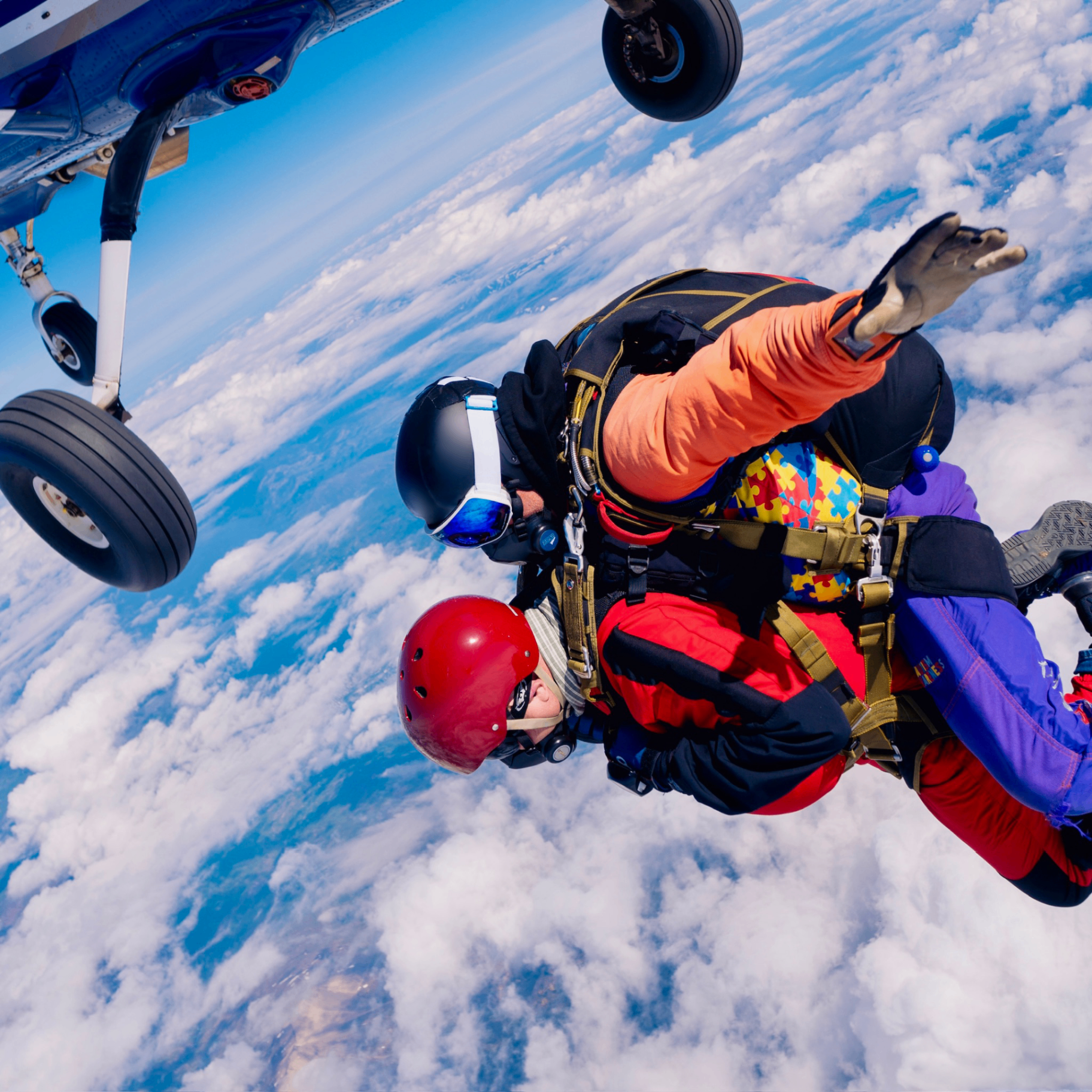 Instructor and tandem student exiting the aircraft above the clouds