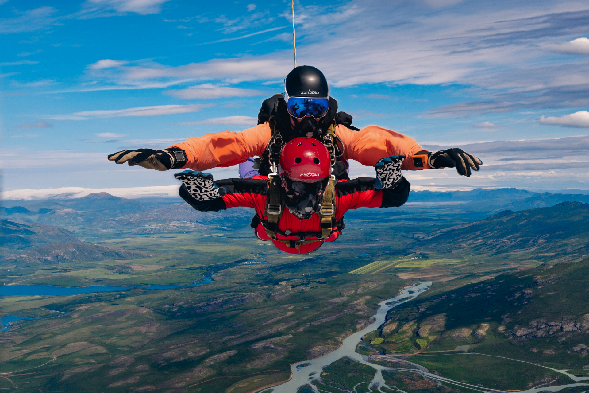 Instructor and tandem guest in freefall over Iceland's rivers and green valleys
