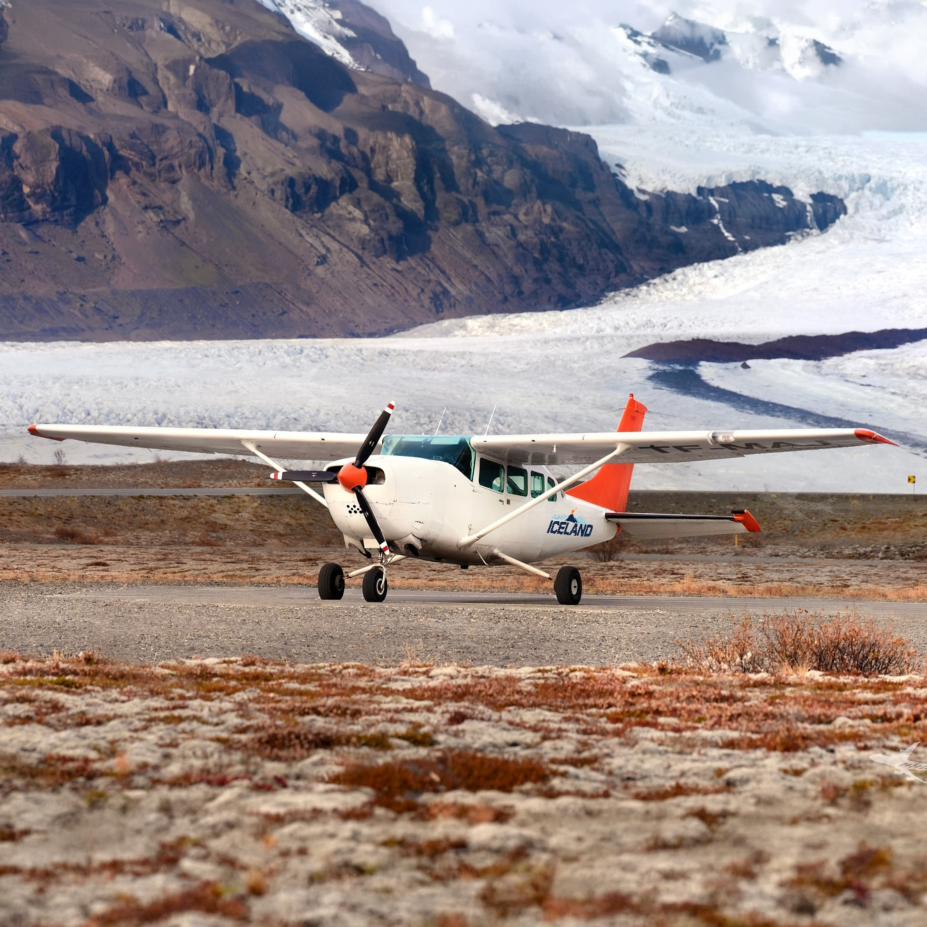 Skydivers exiting a red helicopter over Iceland