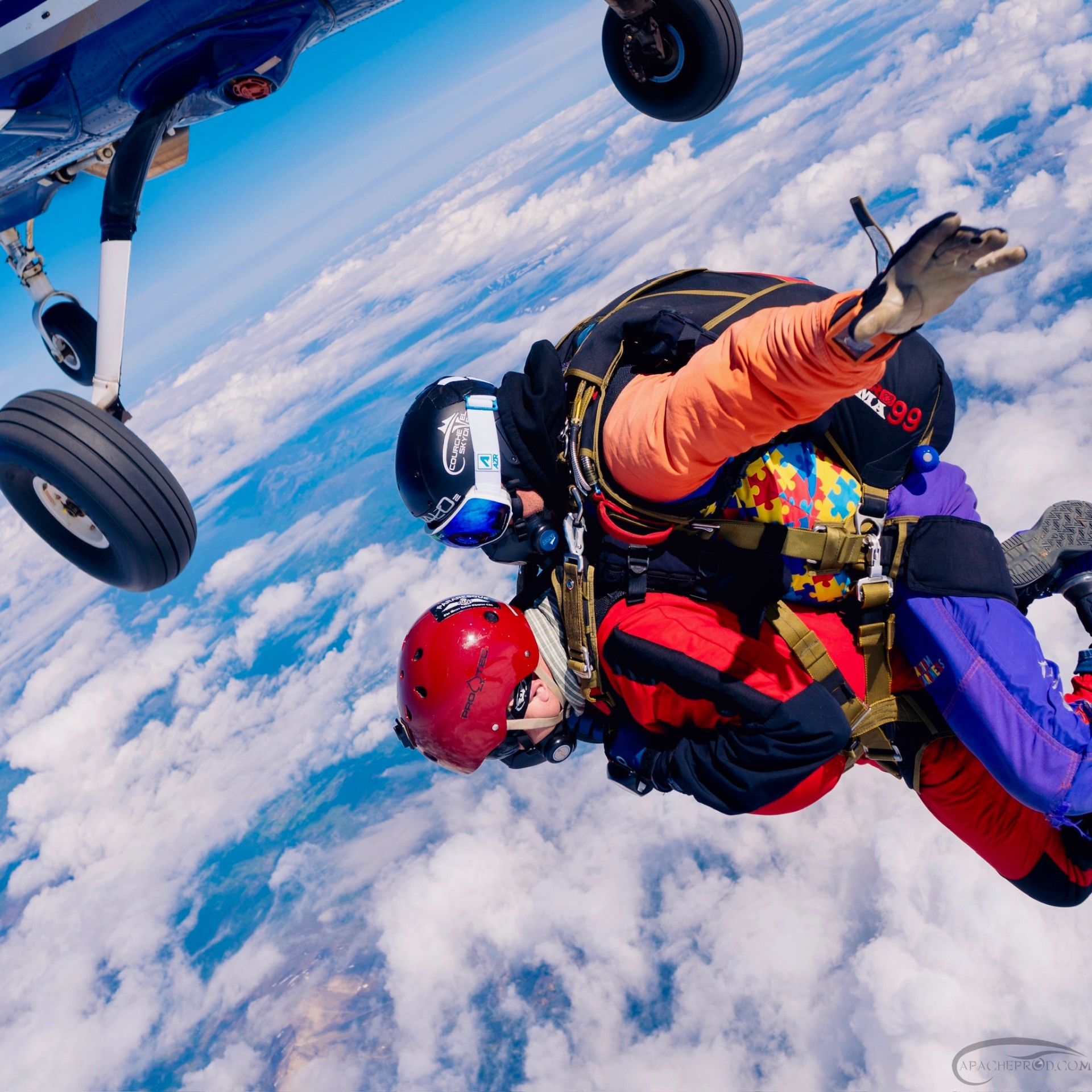 Tandem pair exiting the airplane into blue skies