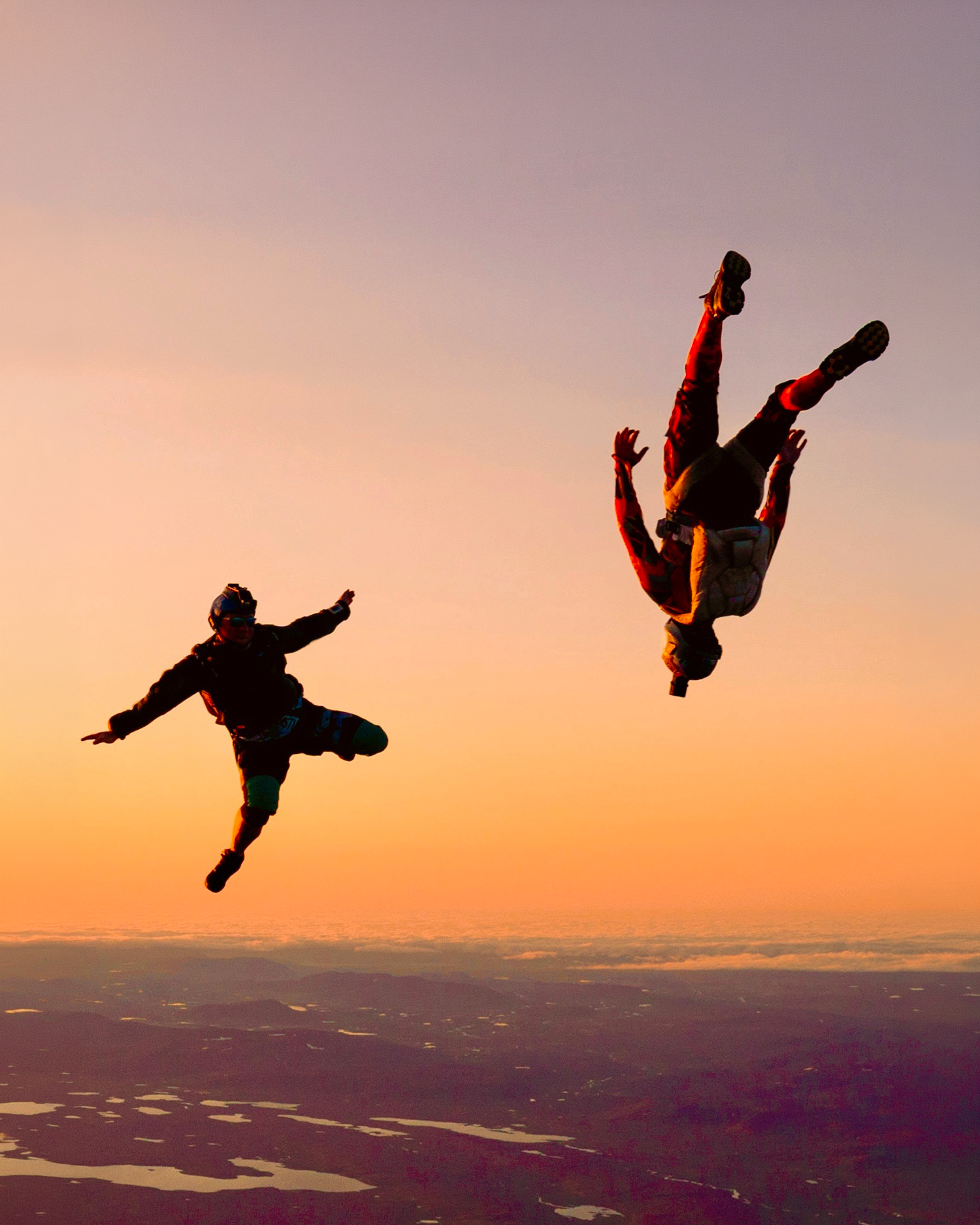 Two licensed skydivers in freefall at sunset over Iceland